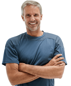 Older man with grey hair standing and smiling with his arms crossed.