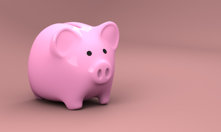 Pink piggy bank used for saving money against a darker pink background