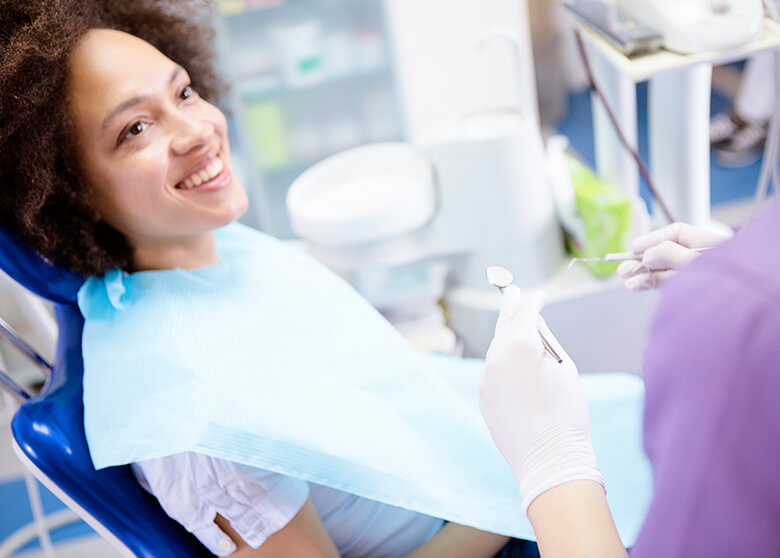 woman sitting in a dental chair, about to have her teeth examined