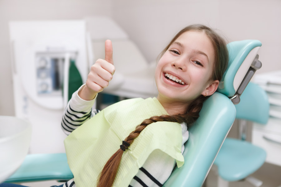 Girl in the dental chair for a hygiene cleaning and exam.